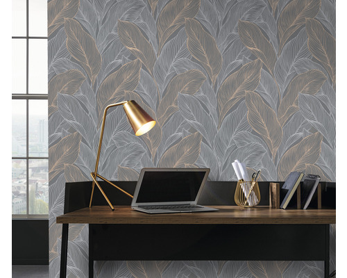 Arbetsrum med blad-mönstrad tapet, skrivbord och lampa