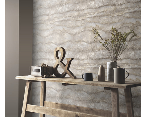 Närbild av en vägg med marmortapet ovanför ett träbord med dekorationer