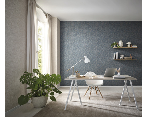 Ljust arbetsrum med skrivbord, stol, krukväxt och mönstrad tapet