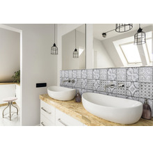 Badrum med dubbla handfat, spegel, kaklat bakstycke och belysning