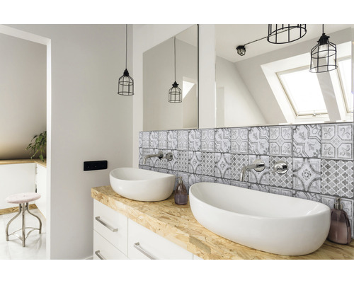 Badrum med dubbla handfat, spegel, kaklat bakstycke och belysning