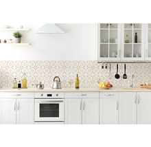 Ljust kök med vita skåp och stänkskydd med blommönster