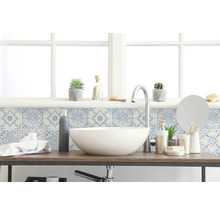 Badrum med handfat, armatur, spegel och dekorativa plattor