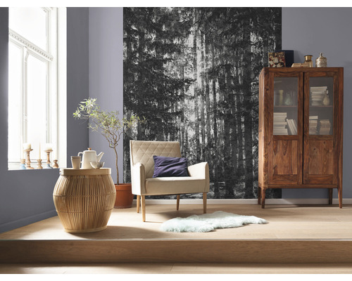 Vardagsrum med fåtölj, sidobord, träskåp och fototapet med skogsmotiv