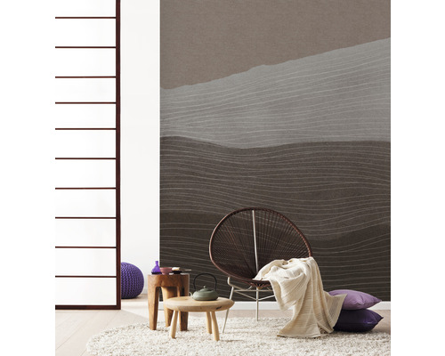 Vardagsrum med mönstrad tapet, fåtölj, matta och sidobord