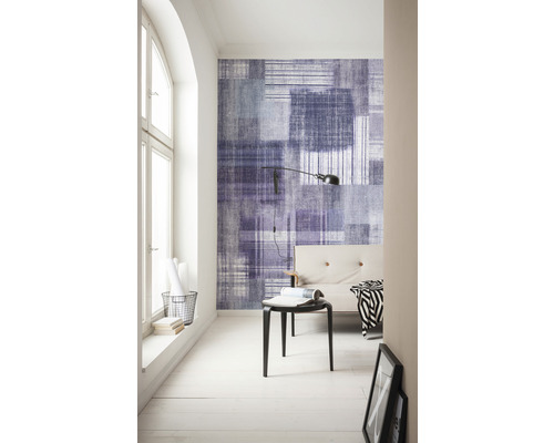 Ljust rum med mönstrad tapet, soffa och lampa