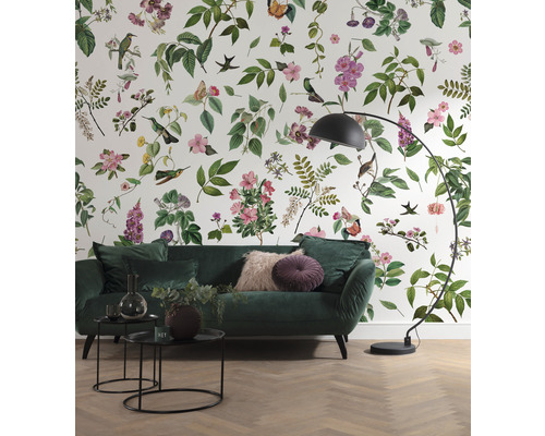 Vardagsrum med mönstrad tapet, soffa, bord och lampa