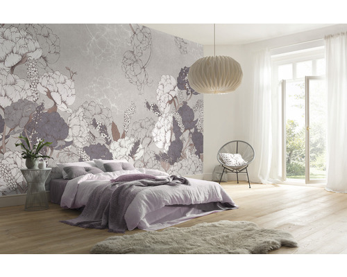 Sovrum med blommig tapet, säng, stol och lampa