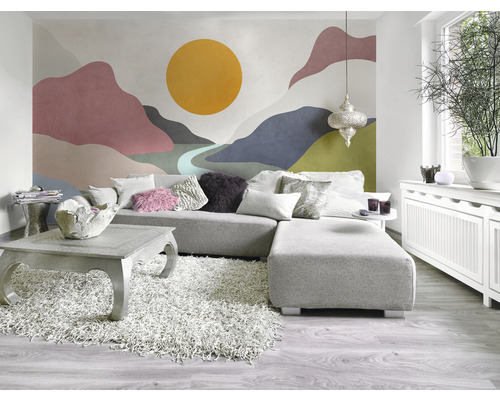 Vardagsrum med hörnsoffa, soffbord, matta och väggtapet med bergsmotiv