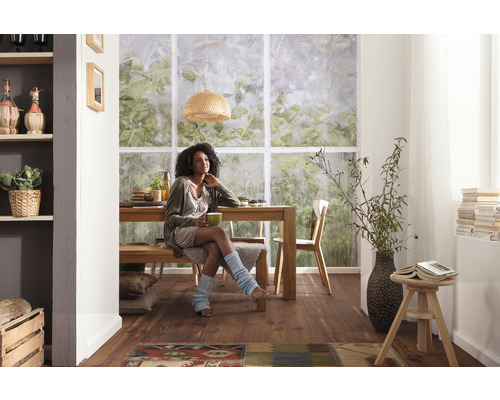 Ljus matplats med träbord, bänk, stolar och en kvinna.