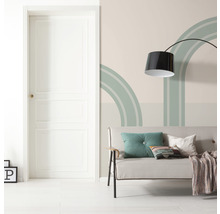 Vardagsrum med dörr, soffa, golvlampa och väggdekoration med geometriska former