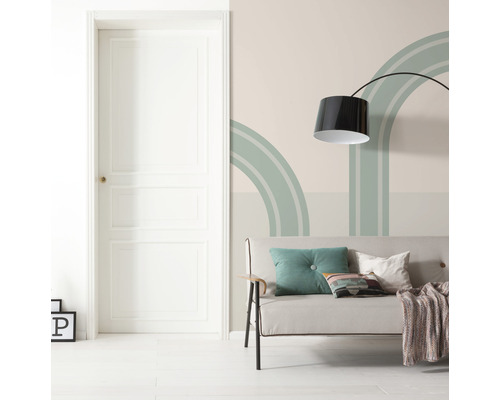 Vardagsrum med dörr, soffa, golvlampa och väggdekoration med geometriska former