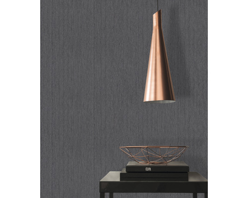 Grå tapet med textil struktur, bord med dekoration och lampa