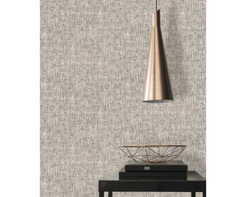 Närbild av en strukturerad tapet med en lampa och dekorativa föremål på ett bord