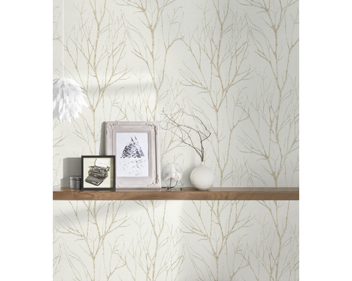 Scen med en tapet med trädgrensmotiv, en trähylla och dekorativa föremål som fotoramar och en vas.