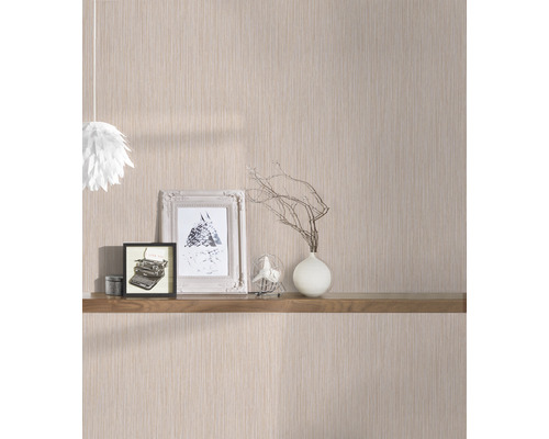 Vardagsrum med mönstrad tapet och trähylla med dekorationer