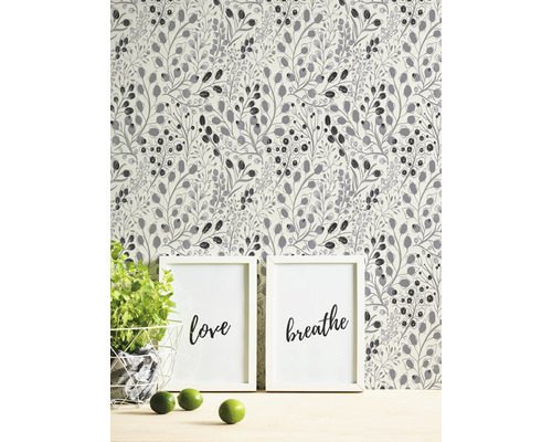 Tapet med växtmönster bakom två inramade konsttryck