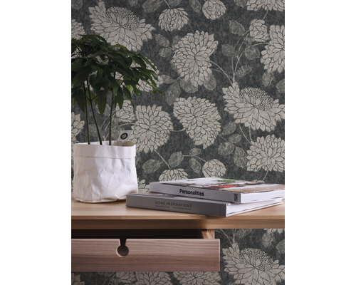 Interiörscen med blommig tapet, träbord med växt och böcker