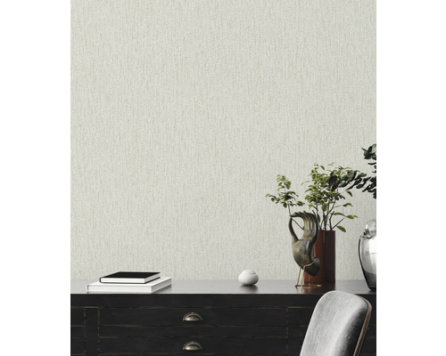 Närbild av en beige non-woven tapet med fin struktur på en vägg