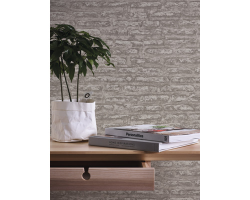 Rum med tapet i stenlook, bord, växt och böcker