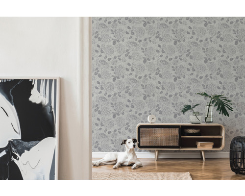 Vardagsrum med blommig tapet, byrå och hund