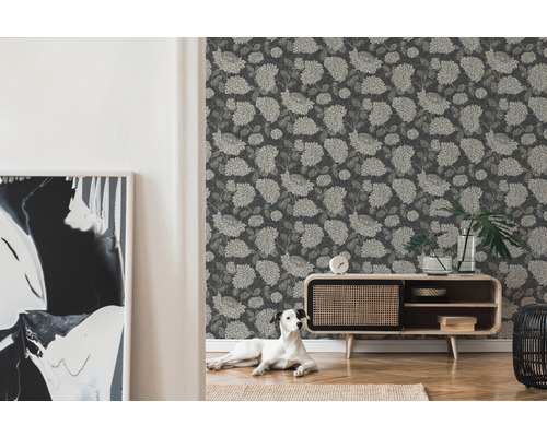 Vardagsrum med blommig tapet, byrå och hund