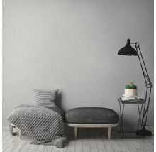 Vardagsrumsinredning med sittbänk, filt, kudde, golvlampa och sidobord