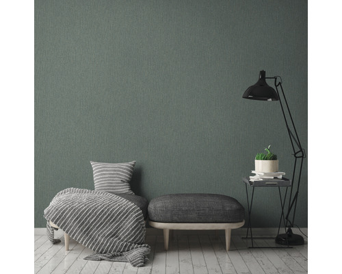 Vardagsrum med grå textiltapet, fåtölj, pall och golvlampa