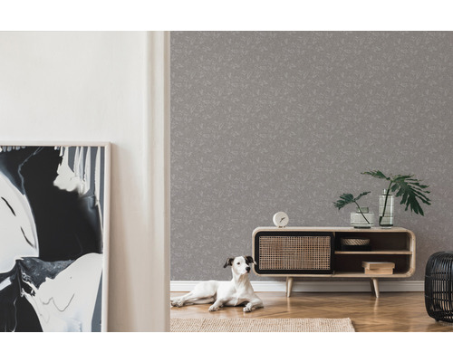 Vardagsrum med grå mönstrad tapet, skänk, krukväxter och hund