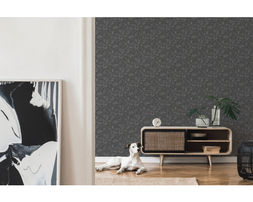 Ett vardagsrum med en grå tapet med mönster, ett träskåp och en hund.