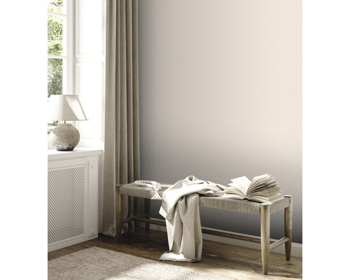 Ljust rum med bänk, bok, tyg och dekor bredvid fönster med gardin