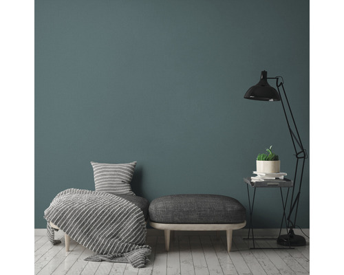 Vardagsrum med fåtölj, pall, golvlampa och dekoration