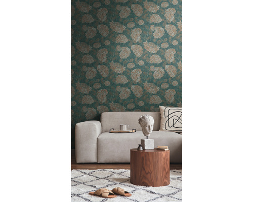 Vardagsrum med mönstrad tapet, soffa och dekorationer på ett träbord