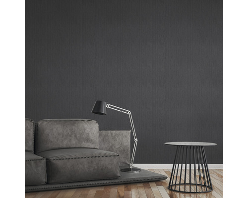 Vardagsrum med soffa, golvlampa och sidobord framför en mörk vägg