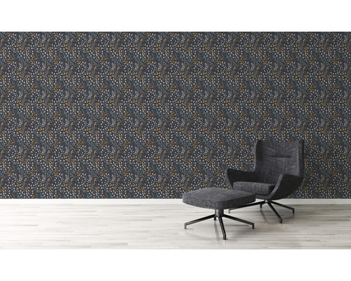 Vardagsrum med mönstrad tapet och fåtölj med fotpall