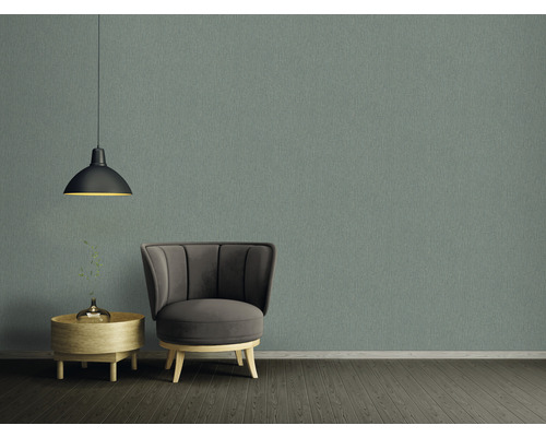 Interiör med fåtölj, lampa, vägg och sidobord