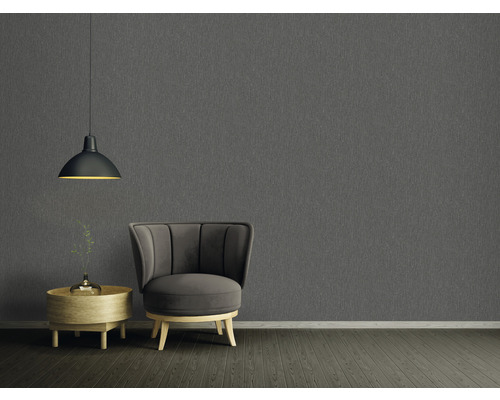 Vardagsrum med grå strukturtapet, fåtölj, sidobord och pendellampa