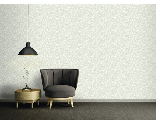 Dekorativ interiör med blommig tapet, fåtölj och lampa