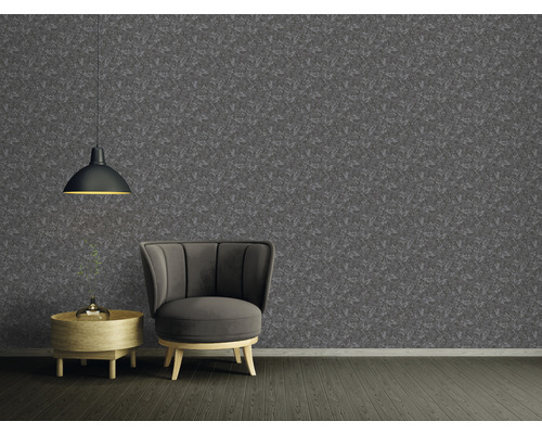 Vardagsrum med mönstrad tapet, fåtölj och hängande lampa