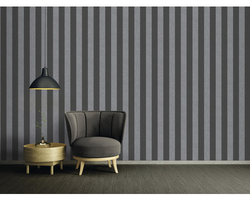 Vardagsrum med grårandig tapet, fåtölj och sidobord