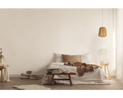 Ljust sovrum med säng, träbord, lampa och dekorativa element