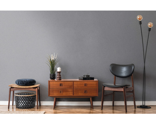 Vardagsrum med träbyrå, stol, pall och golvlampa