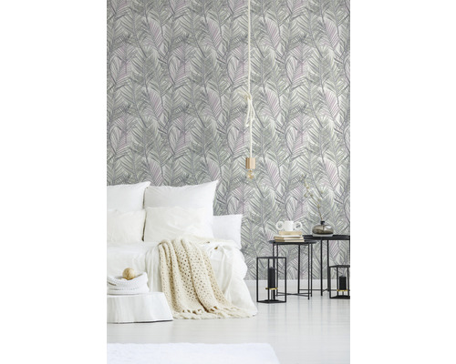 Sovrum med mönstrad tapet, säng, sidobord och dekoration