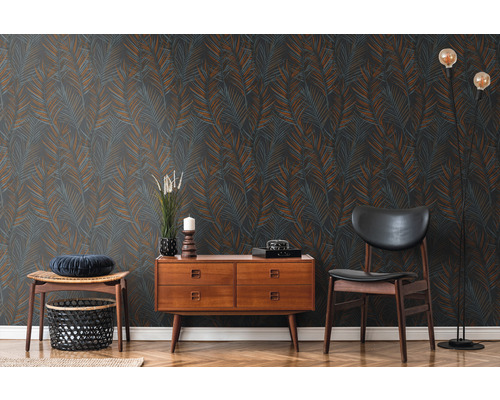 Vardagsrum med mönstrad tapet, byrå, stol och golvlampa