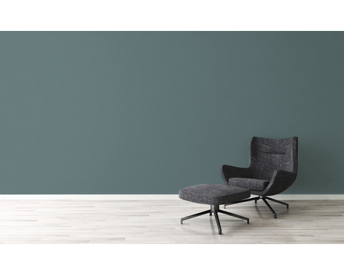 Fåtölj och fotpall framför en vägg