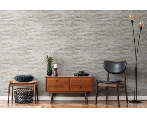 Rumsöversikt med mönstrad tapet, byrå, stol och golvlampa
