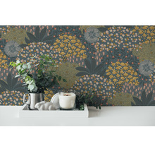Dekorativ tapet med blommönster, kombinerat med ljus, silverkanna och eukalyptus på ett vitt bord.