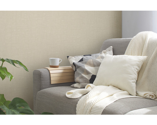 Vardagsrum med grå soffa, kuddar och beige tapet