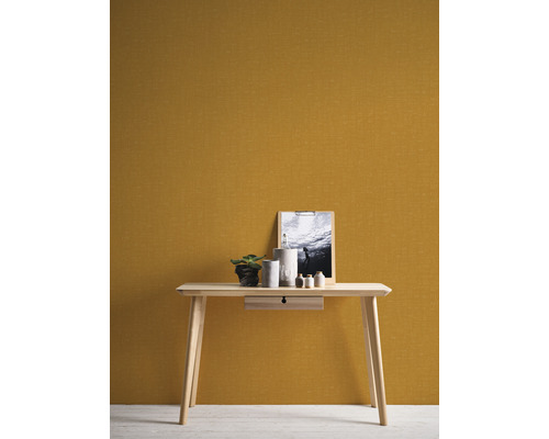 Träbord med låda, dekoration och bild framför en vägg