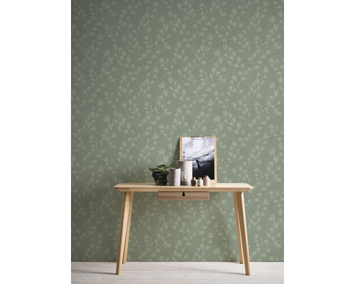 Bild av ett rum med blommig tapet, ett träbord och dekorativa föremål